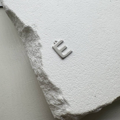 Inicialo pakabukas -  raidelė. Sidabras arba auksas