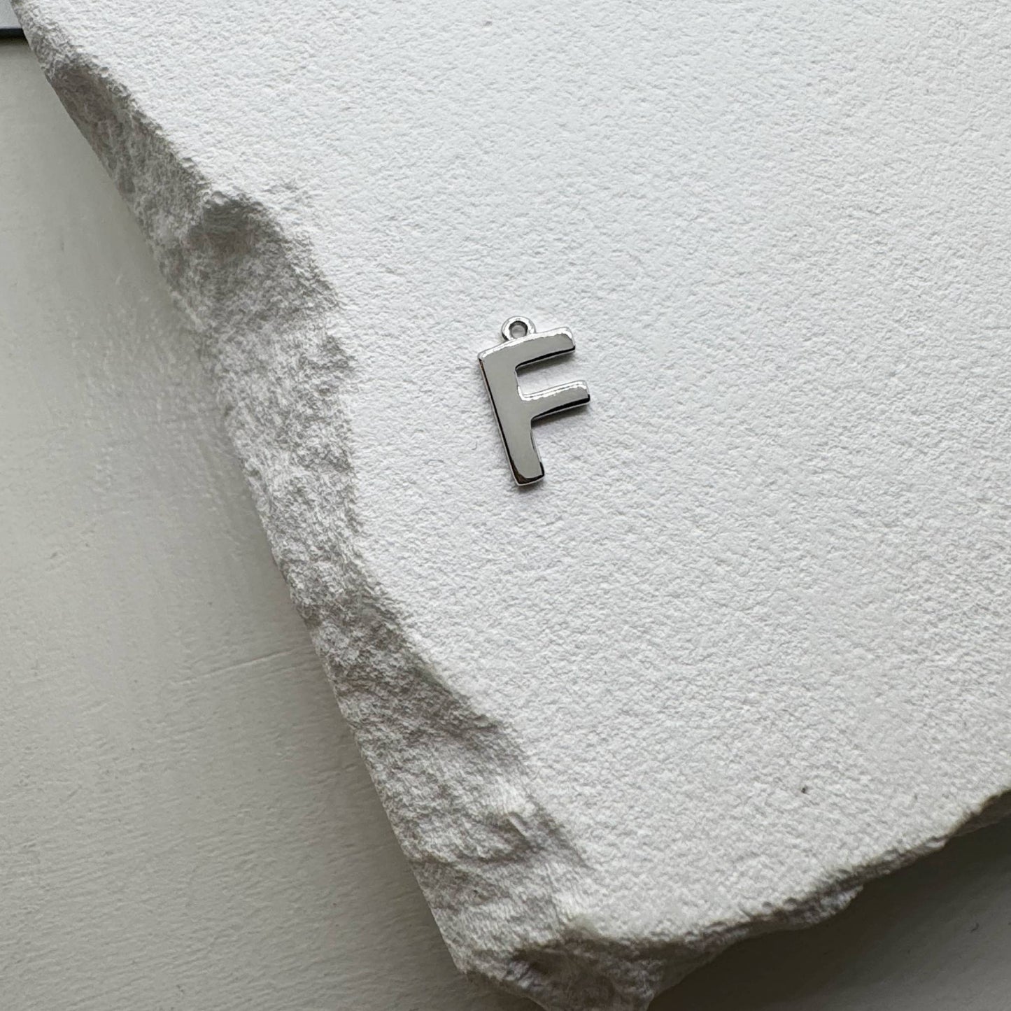 Inicialo pakabukas -  raidelė. Sidabras arba auksas