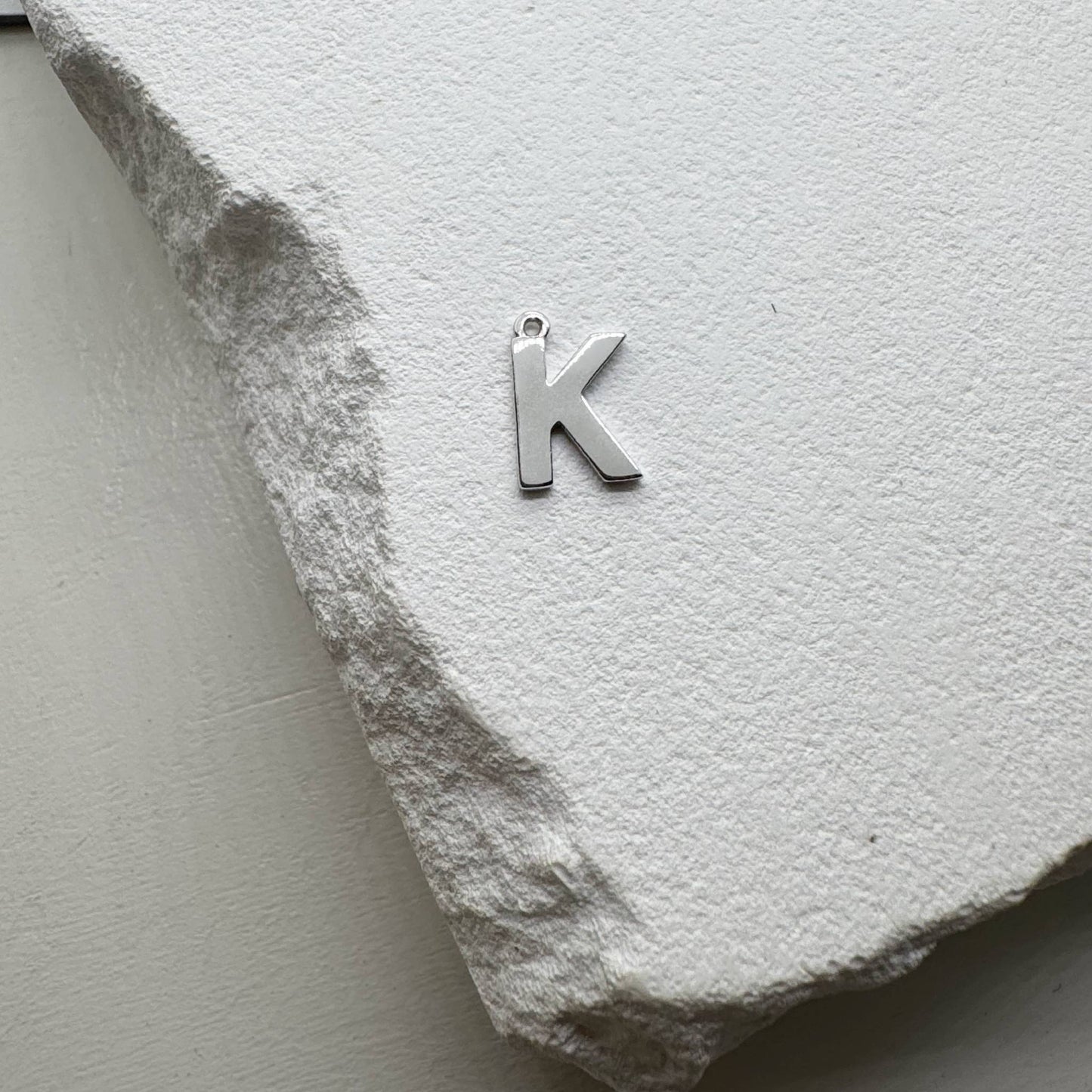 Inicialo pakabukas -  raidelė. Sidabras arba auksas