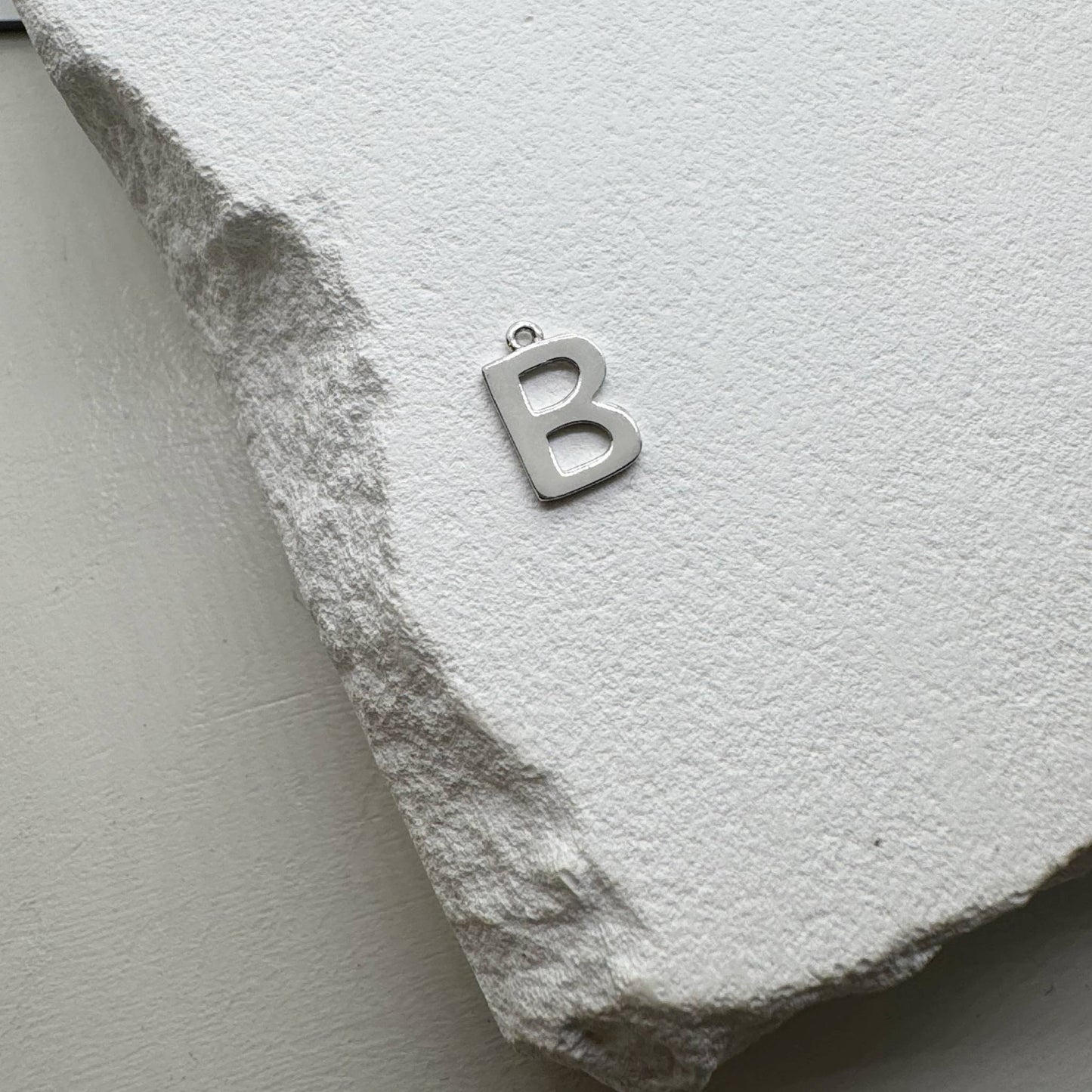 Inicialo pakabukas -  raidelė. Sidabras arba auksas