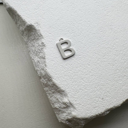 Inicialo pakabukas -  raidelė. Sidabras arba auksas