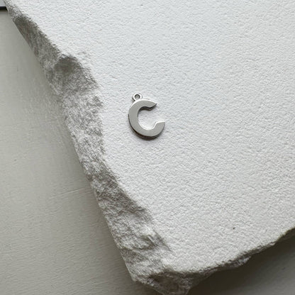 Inicialo pakabukas -  raidelė. Sidabras arba auksas