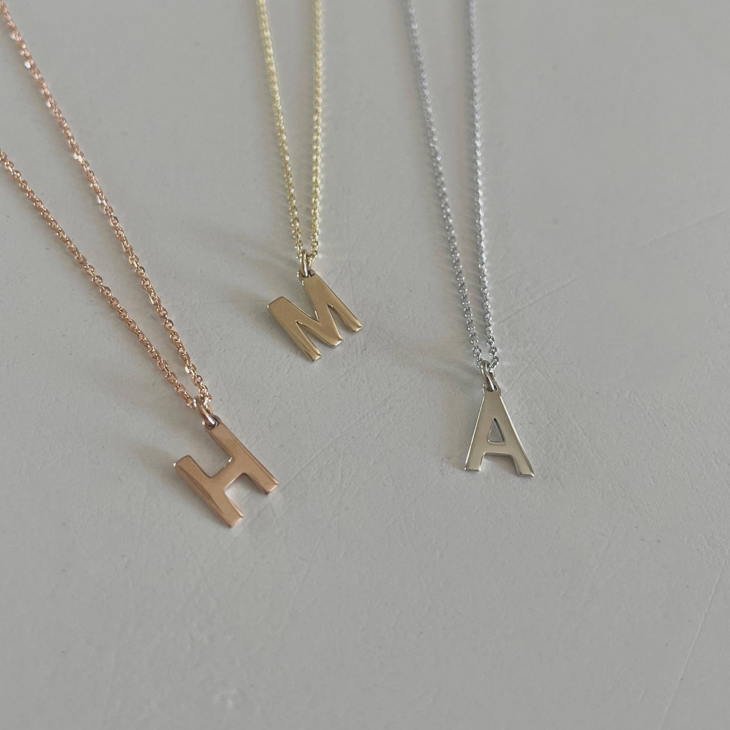 Inicialo pakabukas -  raidelė. Sidabras arba auksas